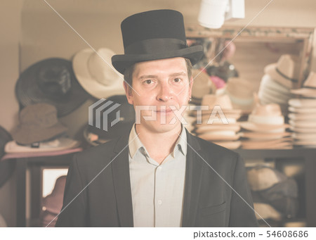 adult male shopping in botique and try on cylinder hat adult male shopping in botique and try on cylinder hat 54608686