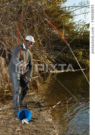 Afro fisherman pulling fish Afro fisherman pulling fish 54608695