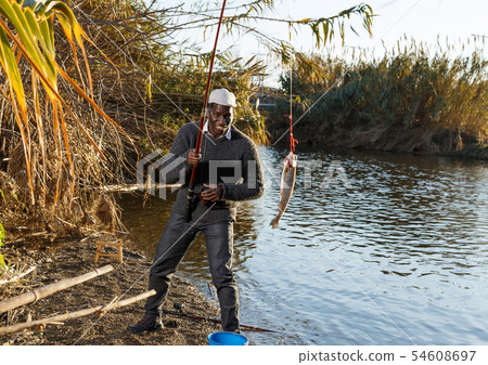 Portrait of enthusiastic African fisherman 54608697