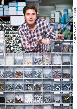Adult male in hardware store is trading goods for construction Adult male in hardware store is trading goods for construction 54608698