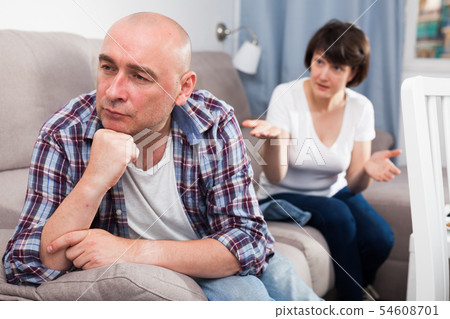 Unhappy mature man after quarrel, woman on background Unhappy mature man after quarrel, woman on background 54608701
