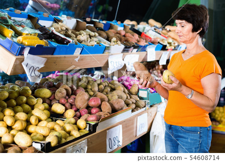 Smiling female is choosing potato in the supermarket. 54608714