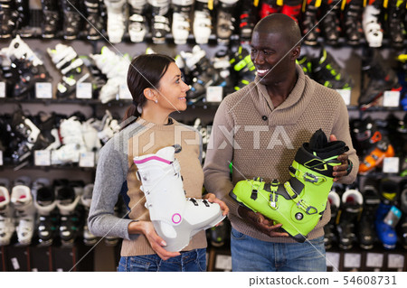 Multiracial couple choosing ski boots Multiracial couple choosing ski boots 54608731