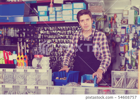 worker in hardware store trading goods for water tap in uniform worker in hardware store trading goods for water tap in uniform 54608757
