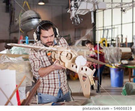 Male creating airplane models 54608819