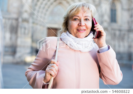 mature female tourist talking on phone mature female tourist talking on phone 54608822