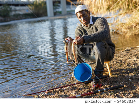 Fisherman holding fish in his hands Fisherman holding fish in his hands 54608834