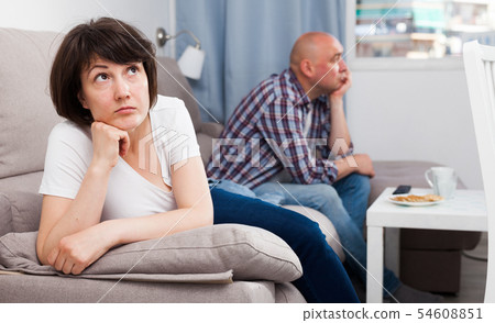Sad family having difficulties in the living room at home Sad family having difficulties in the living room at home 54608851