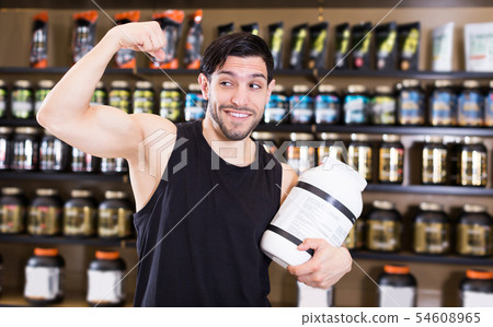 muscular man showing his biceps and holding pot 54608965