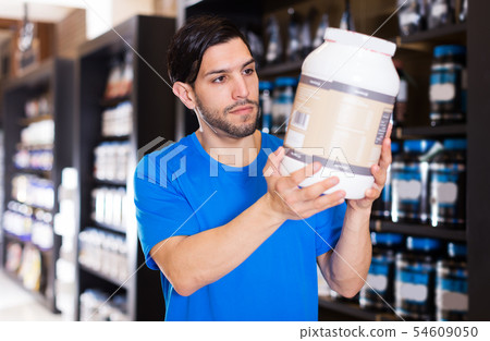 sport man looking different sport nutrition products 54609050