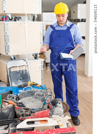 Construction worker inventorying tools and materials Construction worker inventorying tools and materials 54609115