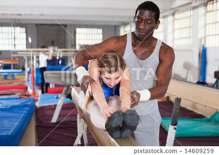 Trainer helping girl at gym 54609259
