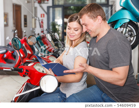 Man with woman are choosing modern motobikes Man with woman are choosing modern motobikes 54609459