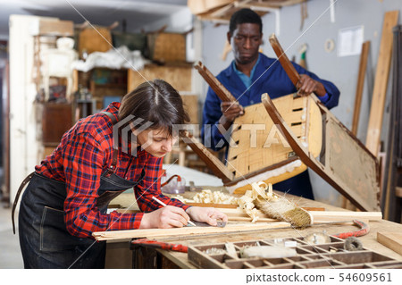 Artisans in process of renewing armchair 54609561