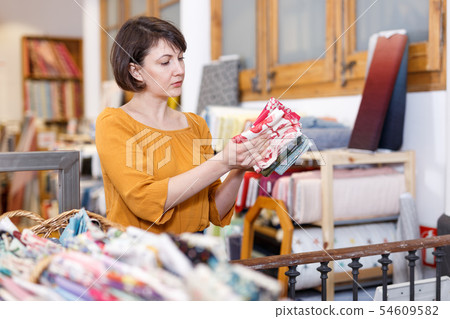 Woman looking for cloth in shop Woman looking for cloth in shop 54609582