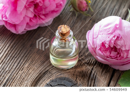 A bottle of rose essential oil with cabbage rose 54609949