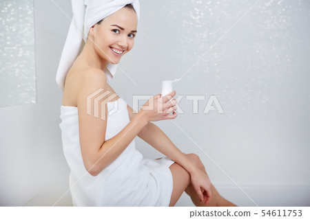 Woman Wrapped with Bath Towels, Applying Cream on 54611753