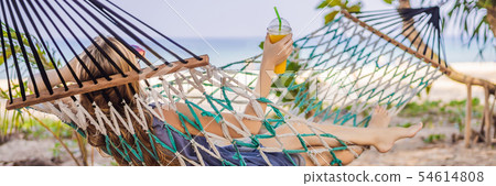 Young woman on the beach in a hammock with a drink BANNER, LONG FORMAT Young woman on the beach in a hammock with a drink BANNER, LONG FORMAT 54614808