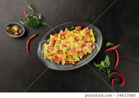 Nachos, Mexican tortilla chips, shot from above with a cheese sauce, chili and jalapeno peppers Nachos, Mexican tortilla chips, shot from above with a cheese sauce, chili and jalapeno peppers 54617060