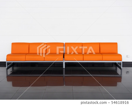 Empty orange sofa in the room near white wall. Waiting hall Empty orange sofa in the room near white wall. Waiting hall 54618916