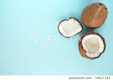 Flat lay with ripe coconuts on blue background.  54621183