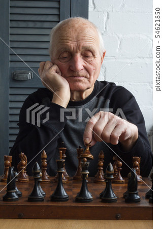 An old man is sitting in front of a chessboard, An old man is sitting in front of a chessboard, 54621850