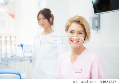 A blond dentist woman in a treatment room A blond dentist woman in a treatment room 54623137