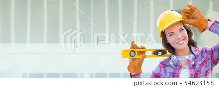 Female Contractor Wearing Hard Hat Against Dywall Female Contractor Wearing Hard Hat Against Dywall 54623158