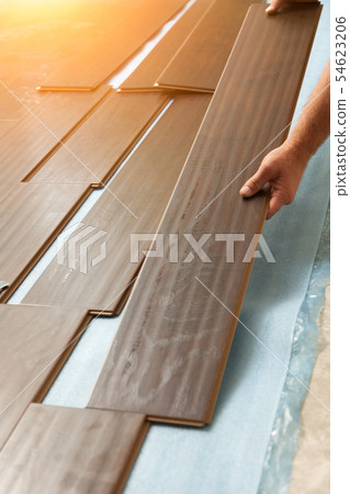Man Installing New Laminate Wood Flooring Man Installing New Laminate Wood Flooring 54623206