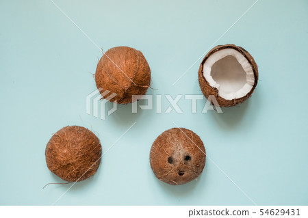 Flat lay with ripe coconuts on blue background.  54629431