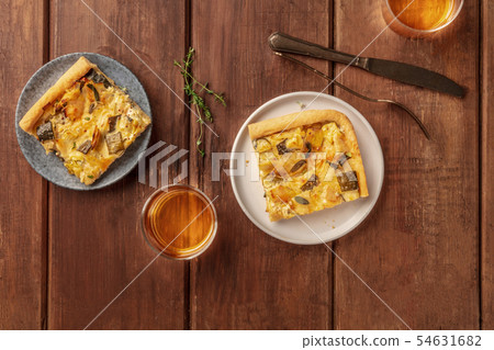 Slices of a zucchini and goat cheese pie with thyme, shot from above on a dark rustic wooden 54631682