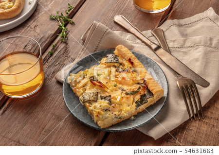 Slices of a zucchini and goat cheese pie with thyme on a dark rustic wooden background with white Slices of a zucchini and goat cheese pie with thyme on a dark rustic wooden background with white 54631683