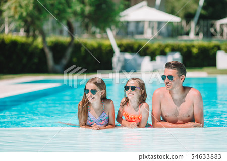 Happy family of four in outdoors swimming pool 54633883