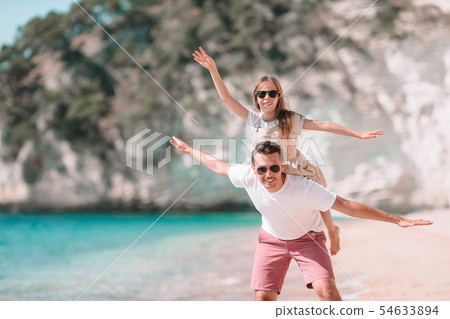 Little girl and happy dad having fun during beach vacation 54633894