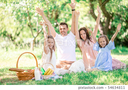 Happy family on a picnic in the park on a sunny day Happy family on a picnic in the park on a sunny day 54634811