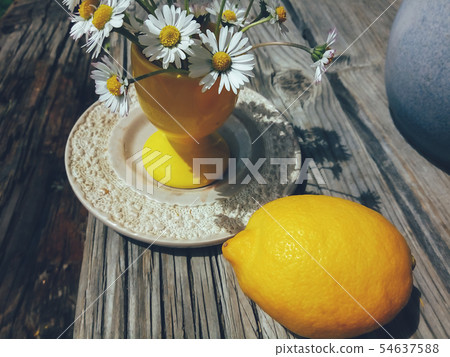 flowers in yellow vase and lemon 54637588