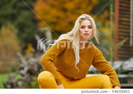 Autumn woman relaxing on a wooden terrace in the Autumn woman relaxing on a wooden terrace in the 54638801