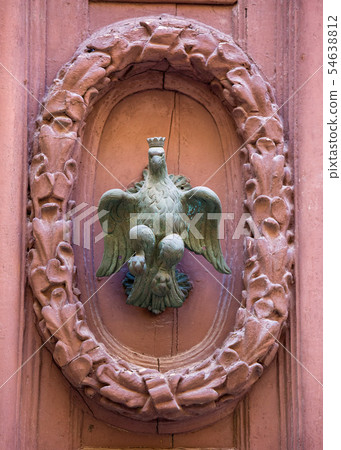 An old style decorative bronze door handle on a wooden door, the distinctive feature and symbol of An old style decorative bronze door handle on a wooden door, the distinctive feature and symbol of 54638812