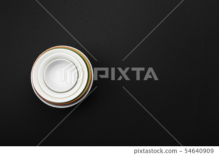 Clean white tableware on black background. Top 54640909