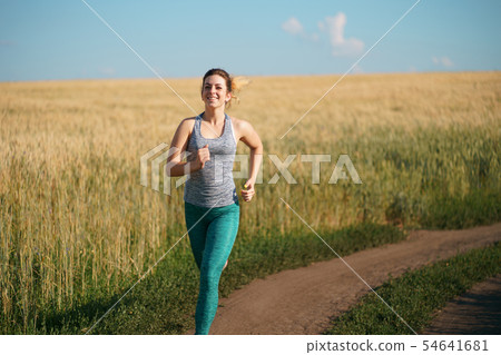 Woman jogger working out in the morning sunny day Woman jogger working out in the morning sunny day 54641681