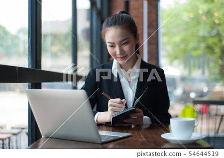 Students take notes of learning from the laptop. 54644519