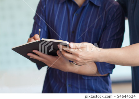 Businessmen take notes in the notebook. 54644524