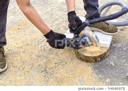The worker cuts a metal plate and paving slabs 54646978
