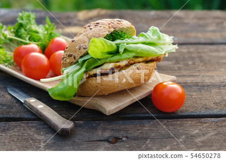 Tasty homemade burger and lettuce, tomatoes. 54650278