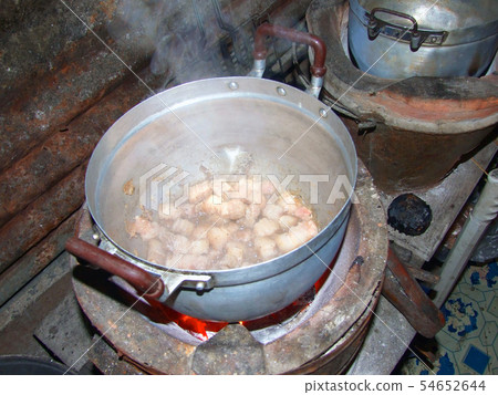 Cooking with pot on charcoal brazier 54652644