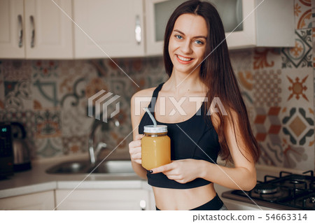Sports girl in a kitchen with fruits Sports girl in a kitchen with fruits 54663314
