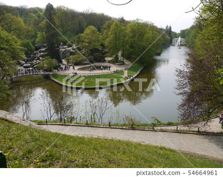 Wide water canal with fountain. Around it there ar Wide water canal with fountain. Around it there ar 54664961