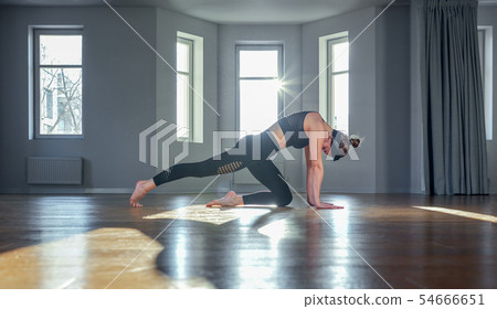 Morning yoga girl doing stretching exercises in the room for Pilates. Beautiful light, air photos, a Morning yoga girl doing stretching exercises in the room for Pilates. Beautiful light, air photos, a 54666651