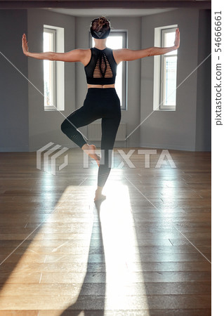 Morning yoga girl doing stretching exercises in the room for Pilates. Beautiful light, air photos, a Morning yoga girl doing stretching exercises in the room for Pilates. Beautiful light, air photos, a 54666661