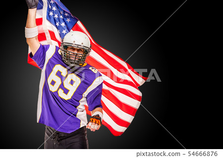 Patriotic american football player posing at camera on black background with usa flag. The concept 54666876